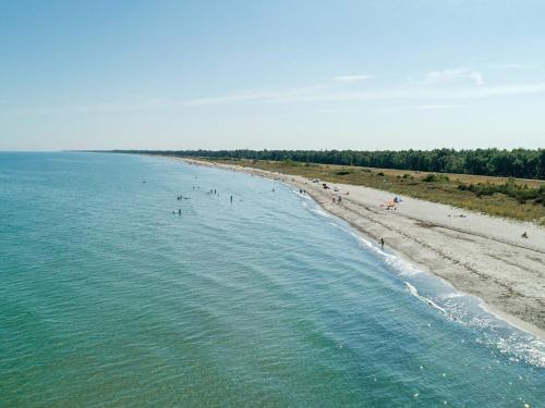 an aerial view of a beach with people in the water at 6 person holiday home in Væggerløse in Bøtø By