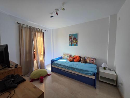 a bedroom with a blue bed and a television at La Casa Sahi in Gáldar