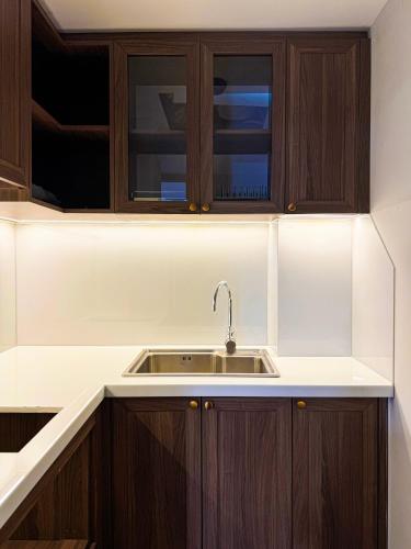 a kitchen with wooden cabinets and a sink at CityHouse TERA The S in Ho Chi Minh City