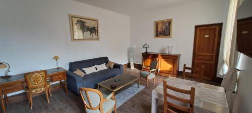 a living room with a blue couch and a table at Le Clos du Bohon, 90m2 , calme dans l'Oise ,15 mn de Gisors et son chateau in Labosse