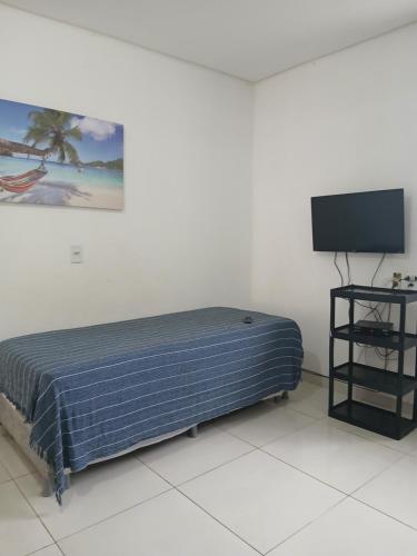 a bed in a room with a flat screen tv at Lotus Antunes Beach in Antunes