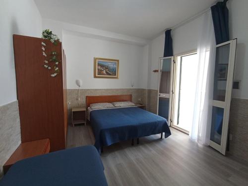 a bedroom with a bed and a large window at Hotel Residence Villa Ascoli in Vieste