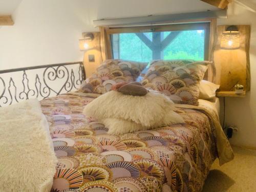 a stuffed dog is sitting on a bed at Chalet La Bohème in Prouilly
