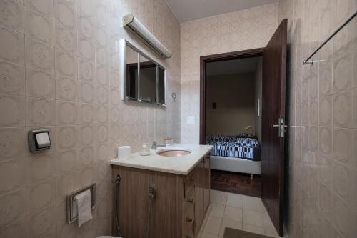 a bathroom with a sink and a mirror at CASA 230 - Guest House in Piracicaba