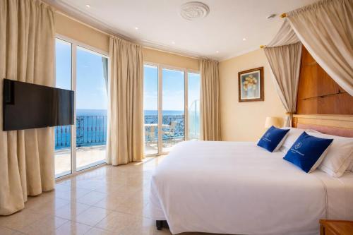 a bedroom with a large bed and a large window at LVG Hotel Collection - Grand Hotel Mediterranee in Alassio