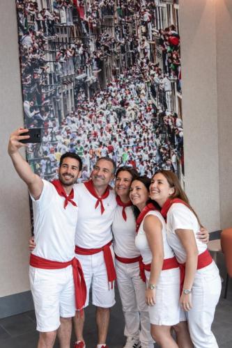 a group of people posing for a picture in front of a poster at Hotel Apartamentos San Fermín Pamplona in Pamplona