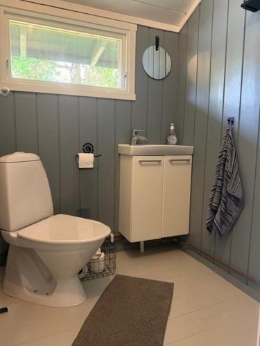 ein Badezimmer mit Toilette, Waschbecken und Fenster in der Unterkunft SOMMERBO- brygge, båt og bil-lader in Kristiansand