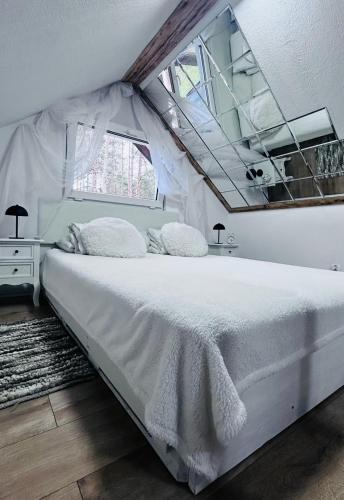 a bedroom with a white bed and a window at CzarnyGaj in Gaj