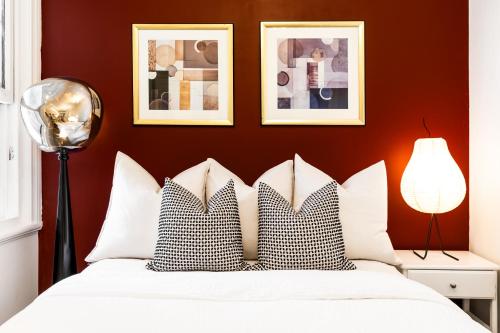 a bedroom with a white bed with two pillows at Ocean-View Art Stay & Private Rooftop, Walk to Circular Quay in Sydney