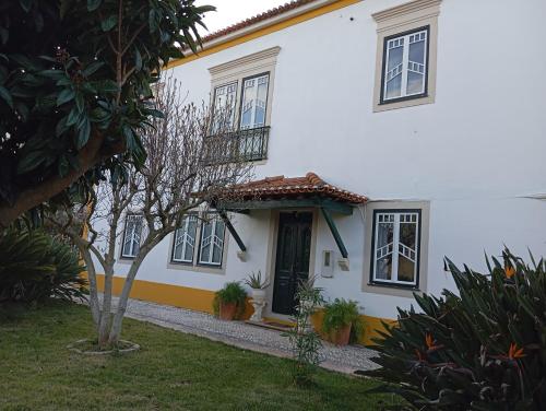 a white house with black windows and a door at St Mary House in Tomar