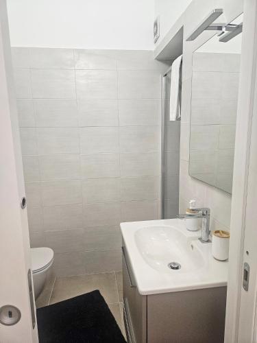 a white bathroom with a sink and a toilet at La Guglia - Maison à Porter in Vasto