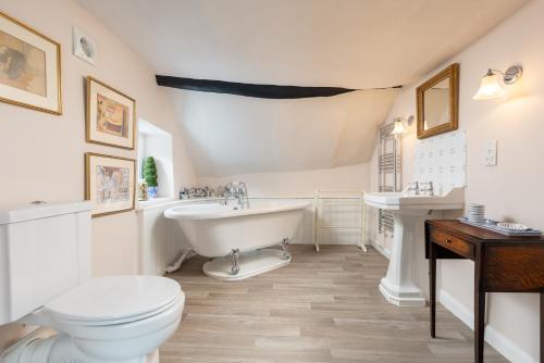 a bathroom with a tub and a toilet and a sink at The Old Sweet Shop in Minehead