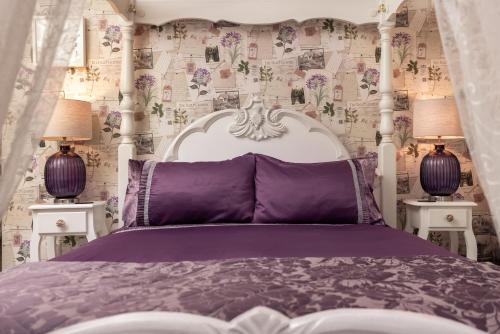 a bedroom with a purple bed with two lamps at The Old Sweet Shop in Minehead