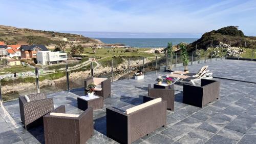 a patio with chairs and a view of the ocean at Vivienda Calas de Costa Quebrada in Soto de la Marina