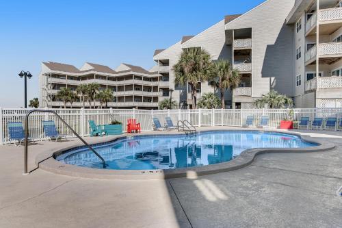 a swimming pool in front of a apartment building at Condo with partial bay view onsite fishing dock beach access & shared pool in Pensacola Beach
