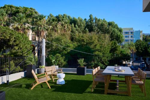 a patio with a table and chairs on the grass at Monarco Executive Rooms in Rhodes Town