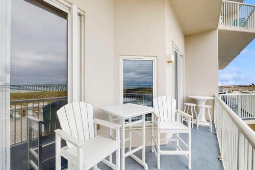 a balcony with a table and chairs and a view of the ocean at Beachfront Condo with amazing views shared pool and beach access in Navarre