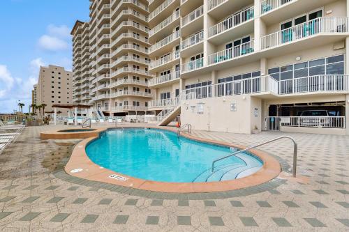 a swimming pool in front of a large apartment building at Beachfront Condo with amazing views shared pool and beach access in Navarre