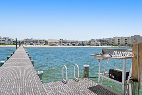 a dock with a boat on top of the water at Sound-Side Condo with Grill Deck & W&D and Shared Pool in Pensacola Beach