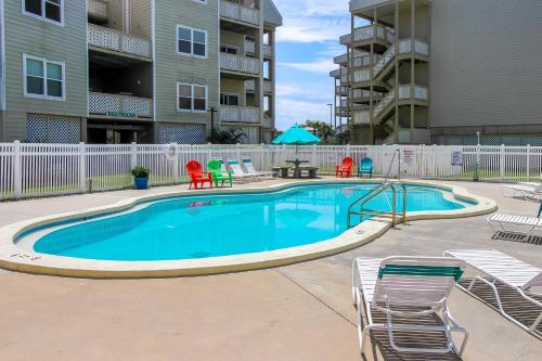 a large swimming pool with chairs and a table at Third-floor beachfront condo with views washer&dryer heated pool in Pensacola Beach