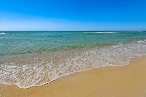a sandy beach with the ocean in the background at Dog-friendly duplex 2 blocks from beach with private yard AC & W&D in Panama City Beach