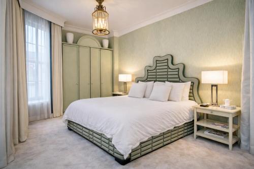 a bedroom with a large bed and a chandelier at Mayfair Green Park Premium Serviced Apartment with 24h Guest Assistance in London