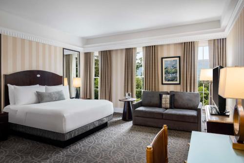 a hotel room with a bed and a couch at The Equinox Golf Resort & Spa in Manchester