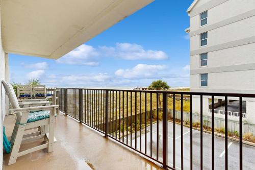 a balcony with a chair and a view of the ocean at Beachfront condo shared pool large balcony and beach access in Navarre