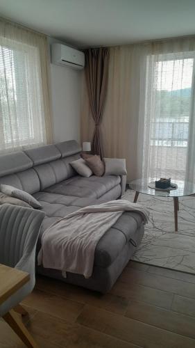 ein Wohnzimmer mit Sofa und Glastisch in der Unterkunft Spa Koncept-Apartmani in Veliko Gradište