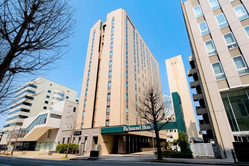 a tall building with a sign in front of it at Richmond Hotel Akita Ekimae in Akita