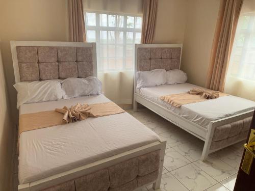 a bedroom with two beds with bows on them at Kristina Gardens in Voi