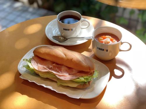 a sandwich and a cup of coffee on a table at APA Hotel Kamata Ekimae in Tokyo