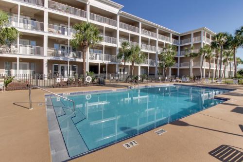 a large swimming pool in front of a building at Cozy top-floor beachfront condo with pool pool spa & beach access in Perdido Key