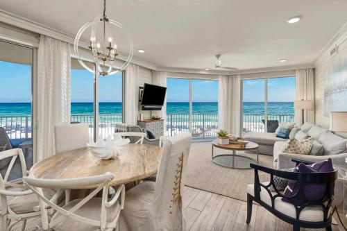 a living room with a table and chairs and the ocean at Stunning beachfront condo with shared pool & beach access in Santa Rosa Beach