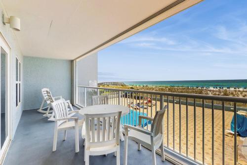 a balcony with a table and chairs and the beach at Beautiful beachfront condo with shared pool & beach access in Fort Walton Beach