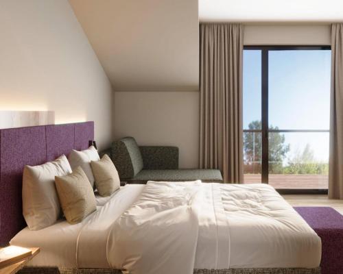 a bedroom with a large white bed and a window at Engels Traumwerk in Wertach