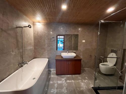 a bathroom with a tub and a sink and a toilet at Emmonlang Resort and Restaurant in Dingpasoh