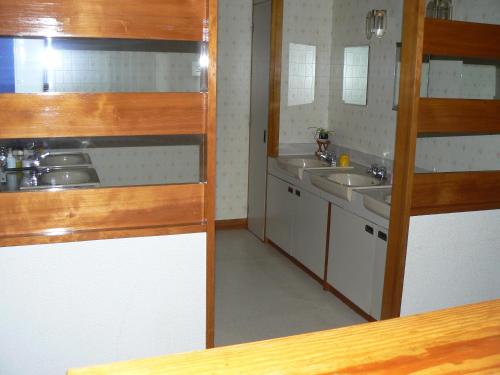 a small bathroom with two sinks and two mirrors at Fureai No Yado Yasuragi in Nozawa Onsen