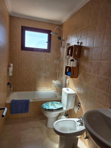 a bathroom with a toilet and a sink and a tub at La Casa Sahi in Gáldar
