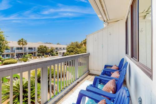 a pair of blue chairs on the balcony of a house at Beautiful coastal studio condo with pool in Santa Rosa Beach