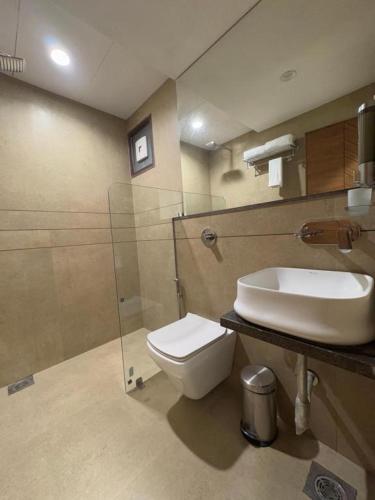 a bathroom with a toilet and a sink at Pam Premium Hotel Vadodara in Vadodara