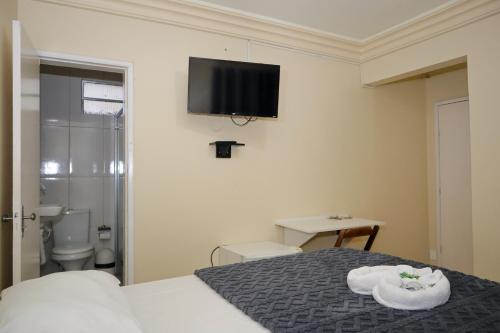 a bedroom with a bed with a flat screen tv on the wall at Diamantina Palace Hotel in Morro do Chapéu