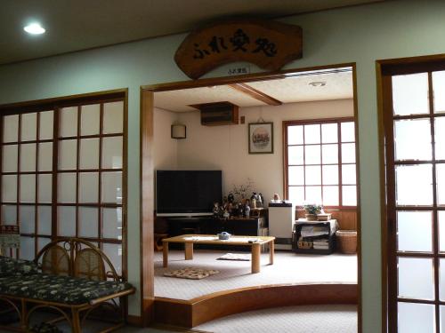 a living room with a door open to a living room at Fureai No Yado Yasuragi in Nozawa Onsen