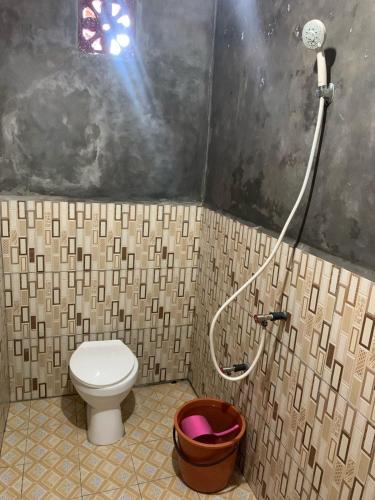 a bathroom with a toilet and a shower at Bunaken Scuba Guest House in Bunaken