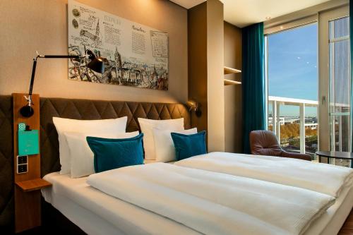 a hotel room with two beds and a window at Motel One München-Messe in Munich
