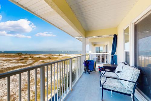 a balcony with a bench and a view of the beach at Bright condo with shared pool beach access & central location in Navarre