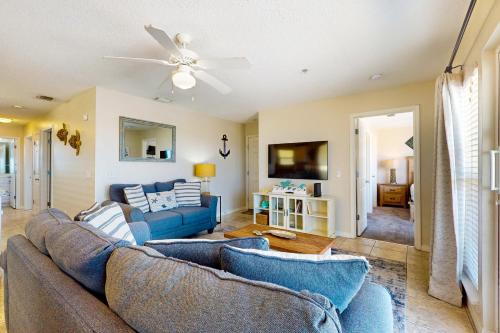 a living room with a couch and a tv at Bright condo with shared pool beach access & central location in Navarre