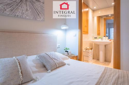 a bedroom with a white bed and a sink at Paradís Platja Apartment in Palamós