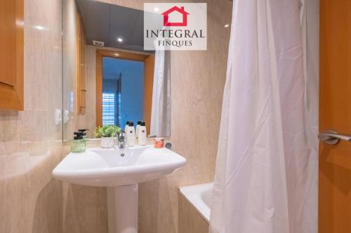 a bathroom with a white sink and a mirror at Paradís Platja Apartment in Palamós