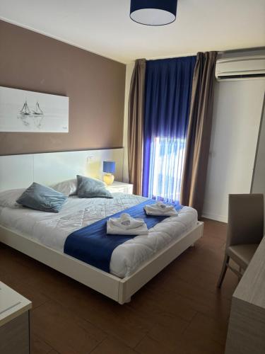a bedroom with a bed with two towels on it at Apart Hotel Atlantic in Grado